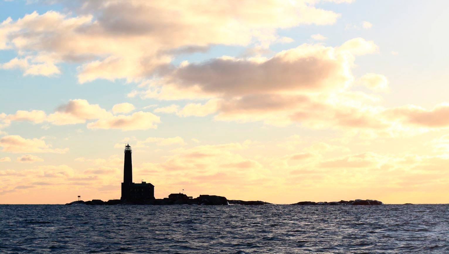 The shadow outline of Bengtskär Lighthouse against a setting sun.
