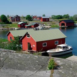Red boathouses line the shore on an island in the Outer Archipelago.