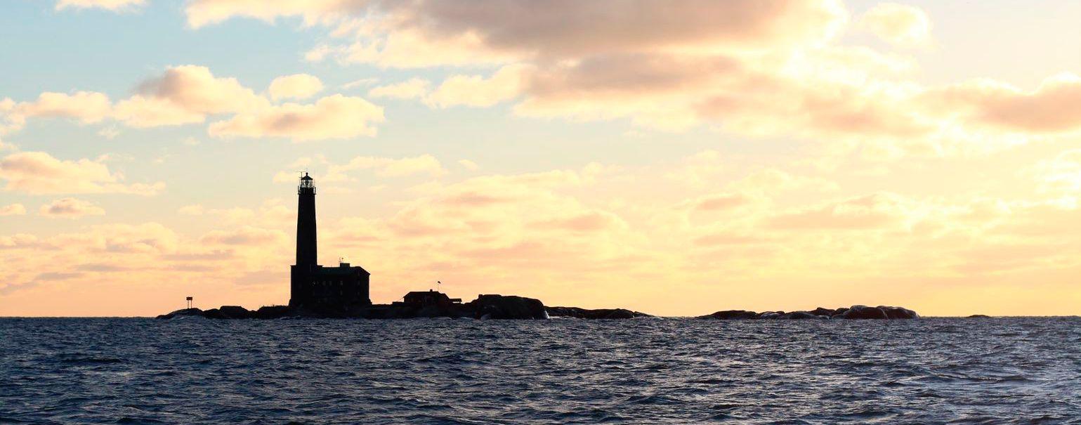 The shadow outline of Bengtskär Lighthouse against a setting sun.