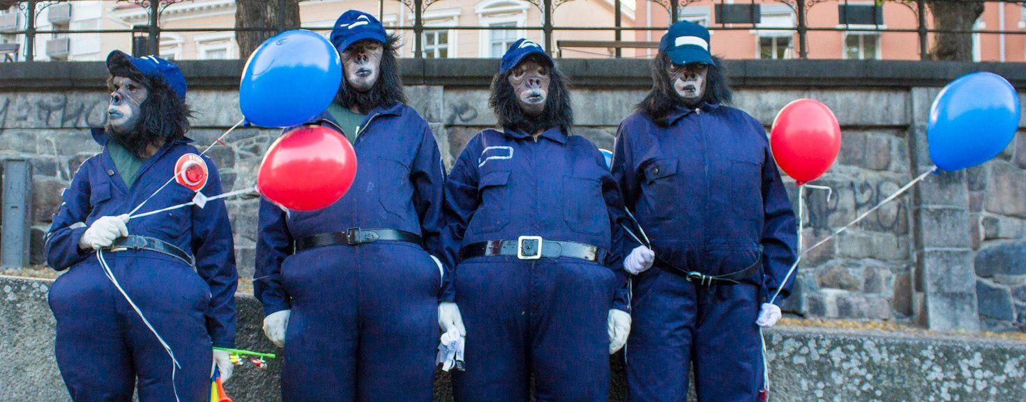 Four members of Aura of Puppets, wearing blue suits and gorilla masks.